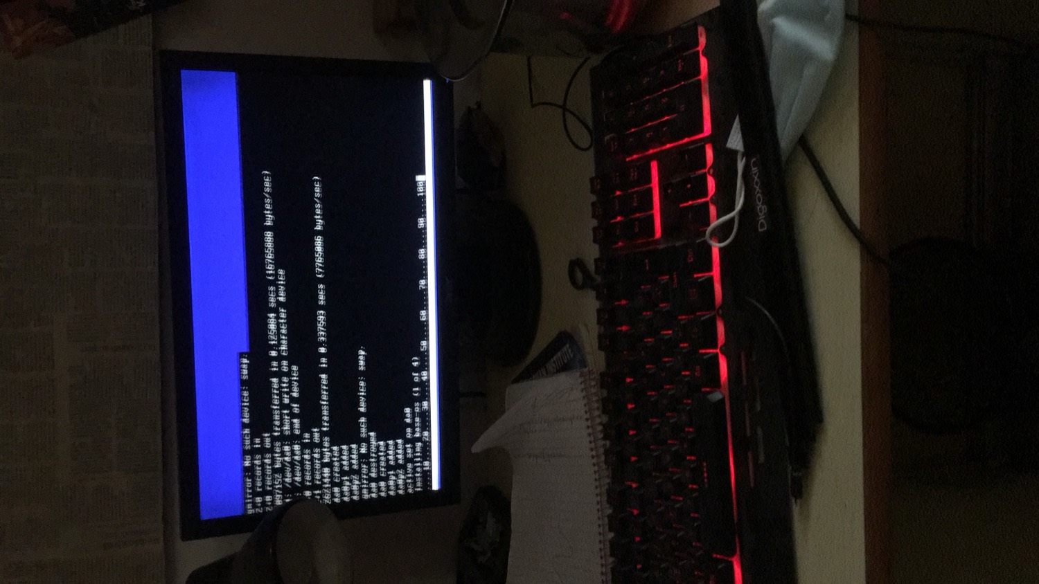 Home desk — a terminal on the monitor and a red-backlit mechanical keyboard