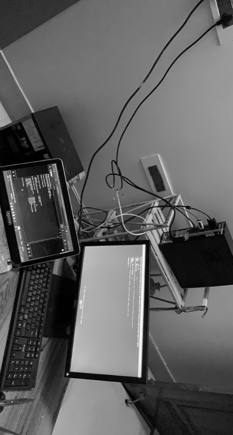 A late-night workspace — laptop, second screen and cables