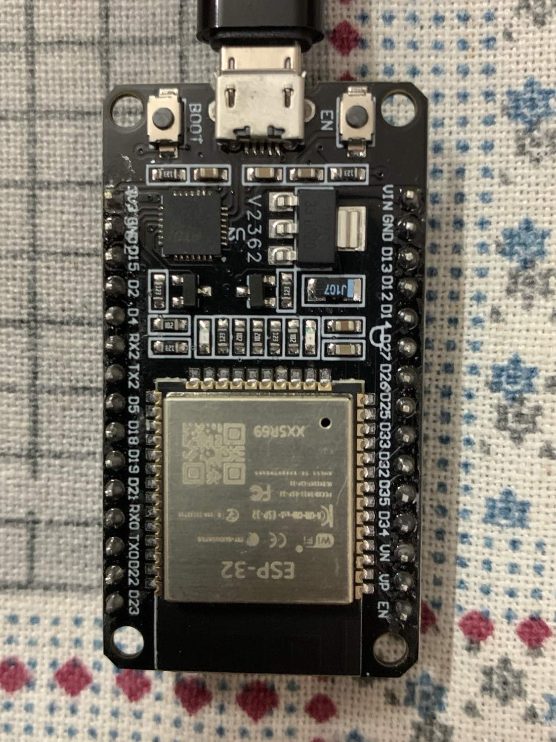 An ESP32 board resting on fabric